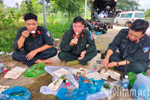Cảnh sát cơ động ăn cơm hộp trên đường hành quân thần tốc đi chống dịch