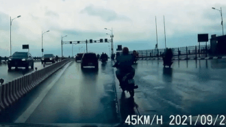 Xe máy ngã sõng soài trước mặt ô tô trên cầu Vĩnh Tuy
