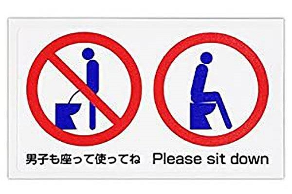 Hình dán minh họa hướng dẫn nam giới bằng tiếng Nhật và tiếng Anh nên ngồi khi sử dụng thiết bị.