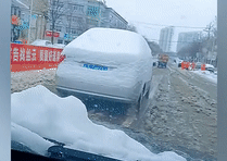 Xe sedan phủ đầy tuyết, tài xế vẫn lái bon bon trên đường