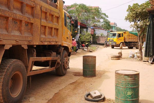 Người dân mang thùng phuy, khúc gỗ chặn đoàn xe tải chở đất