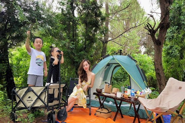 Vợ chồng trẻ chăm cho con đi cắm trại để tận hưởng cuộc sống