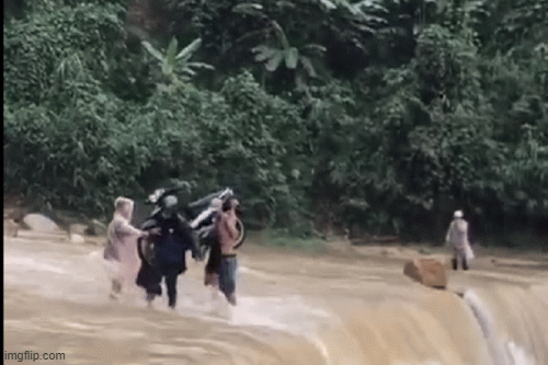 Bốn người liều lĩnh khiêng xe máy vượt dòng lũ chảy xiết