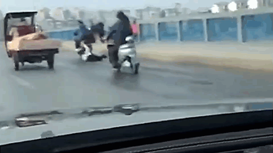 Người đàn ông lái xe máy kéo lê 1 phụ nữ trên đường