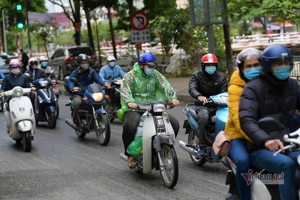 Giữa trưa, người Hà Nội vẫn mặc áo mưa tránh cái rét nhất từ đầu đông - Ảnh 4.