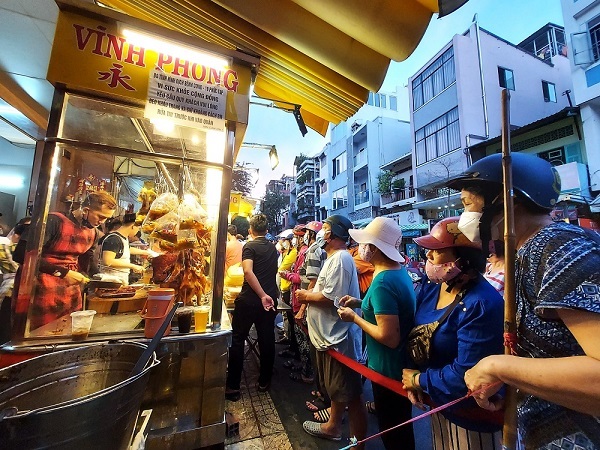 Xếp hàng, quây kín tranh nhau số thứ tự mua heo quay cúng Thần Tài