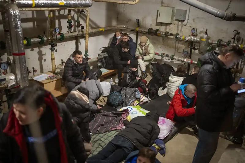 Chú thích 1: Một phụ nữ than khóc bên ngoài tòa chung cư bị tàn phá sau một vụ pháo kích ở Kiev ngày 25/2. Ảnh: AP Chú thích 2: Người dân tìm chỗ trú ẩn dưới tầng hầm một tòa nhà ở Kiev khi còi báo động vang rền khắp thủ đô Ukraina. Ảnh: AP